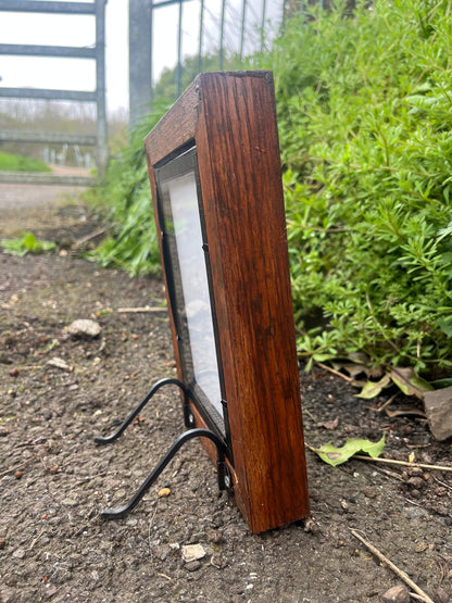 side view of the oak wood heartwood memorial photo frame with a picture of two people on a grassy ground